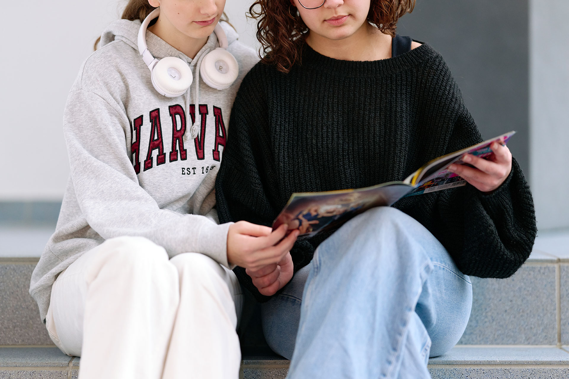 Zwei Jugendliche lesen in einer Zeitschrift