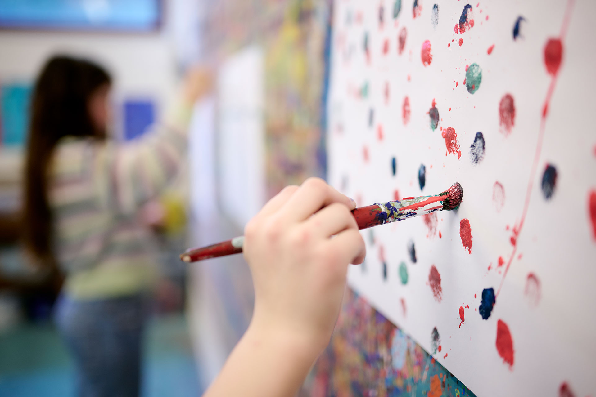 In der Kunsttherapie malt eine Patientin ein Bild.