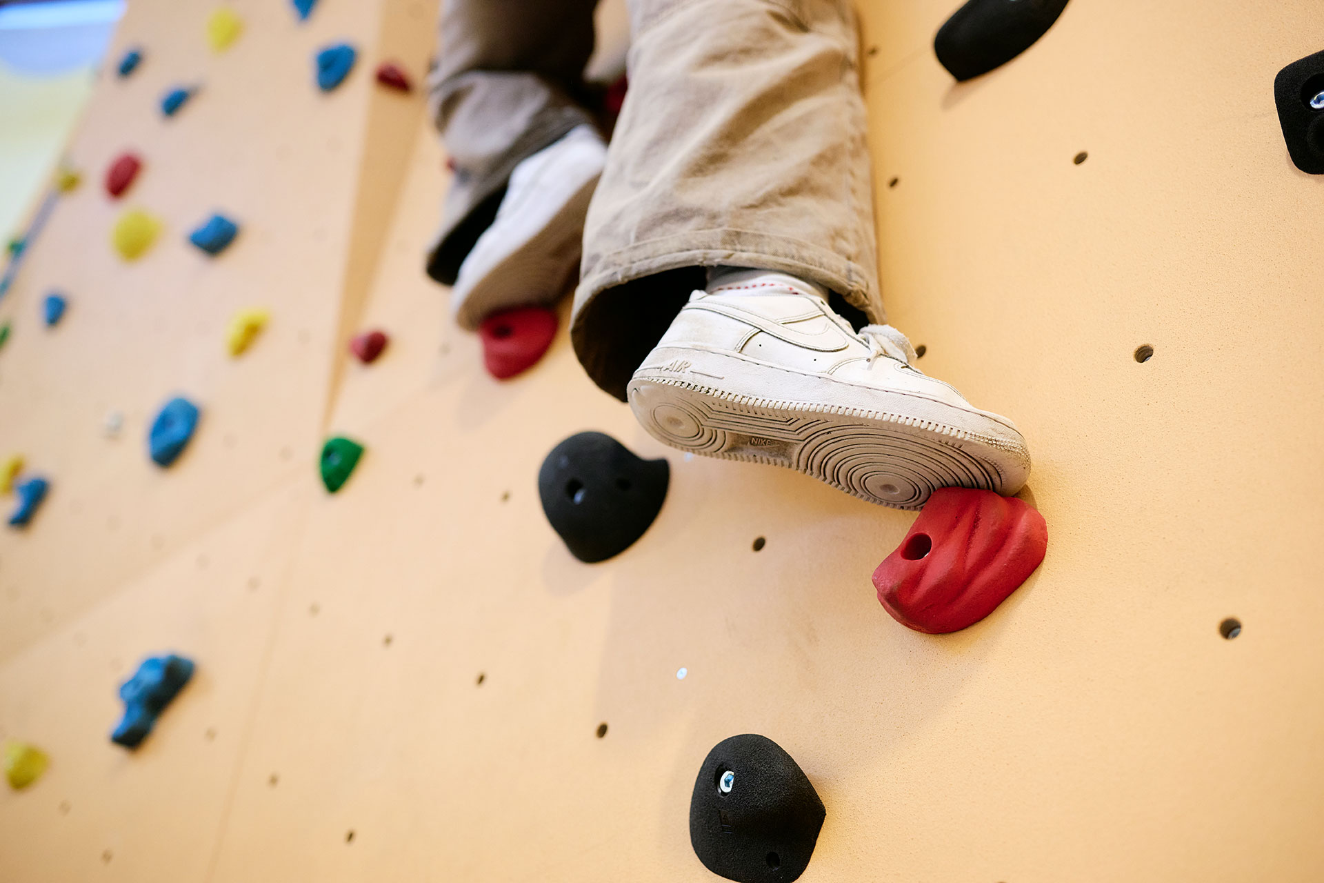 Ein Kind klettert an einer Kletterwand