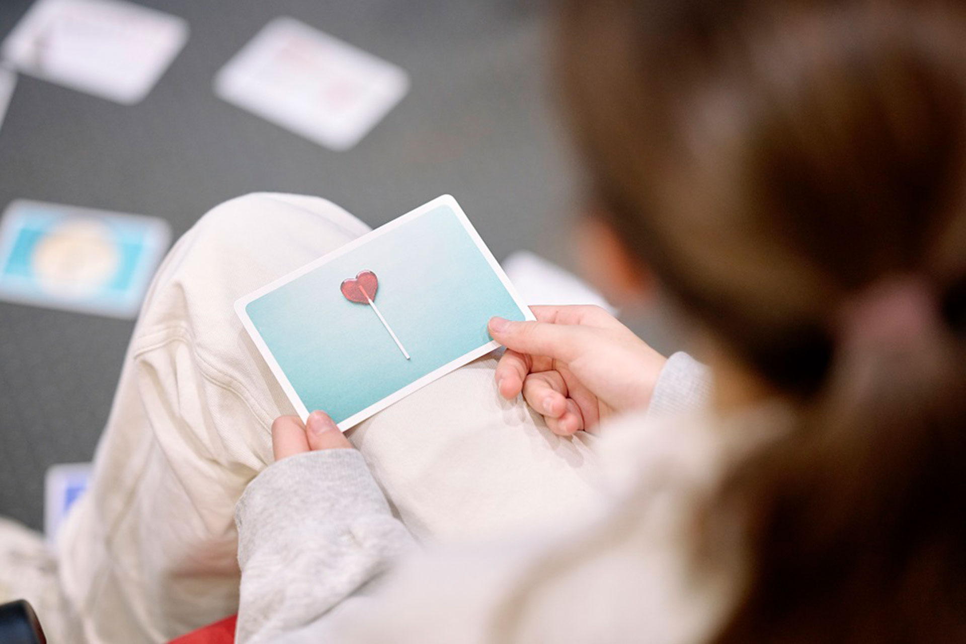 Ein Mädchen hält eine Karte mit einem Herzen in den Händen.
