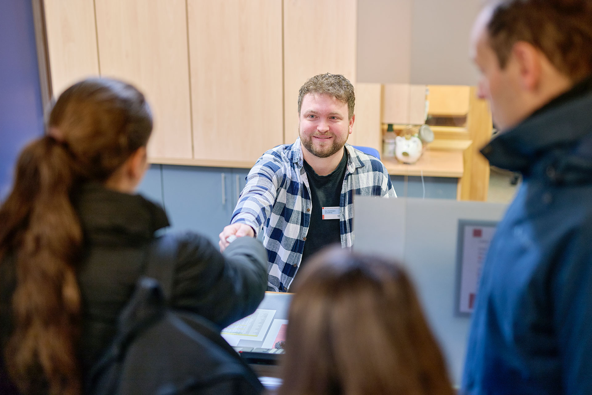 An der Pforte erhält ein Mitarbeiter ein wichtiges Dokumente von einer Familie.