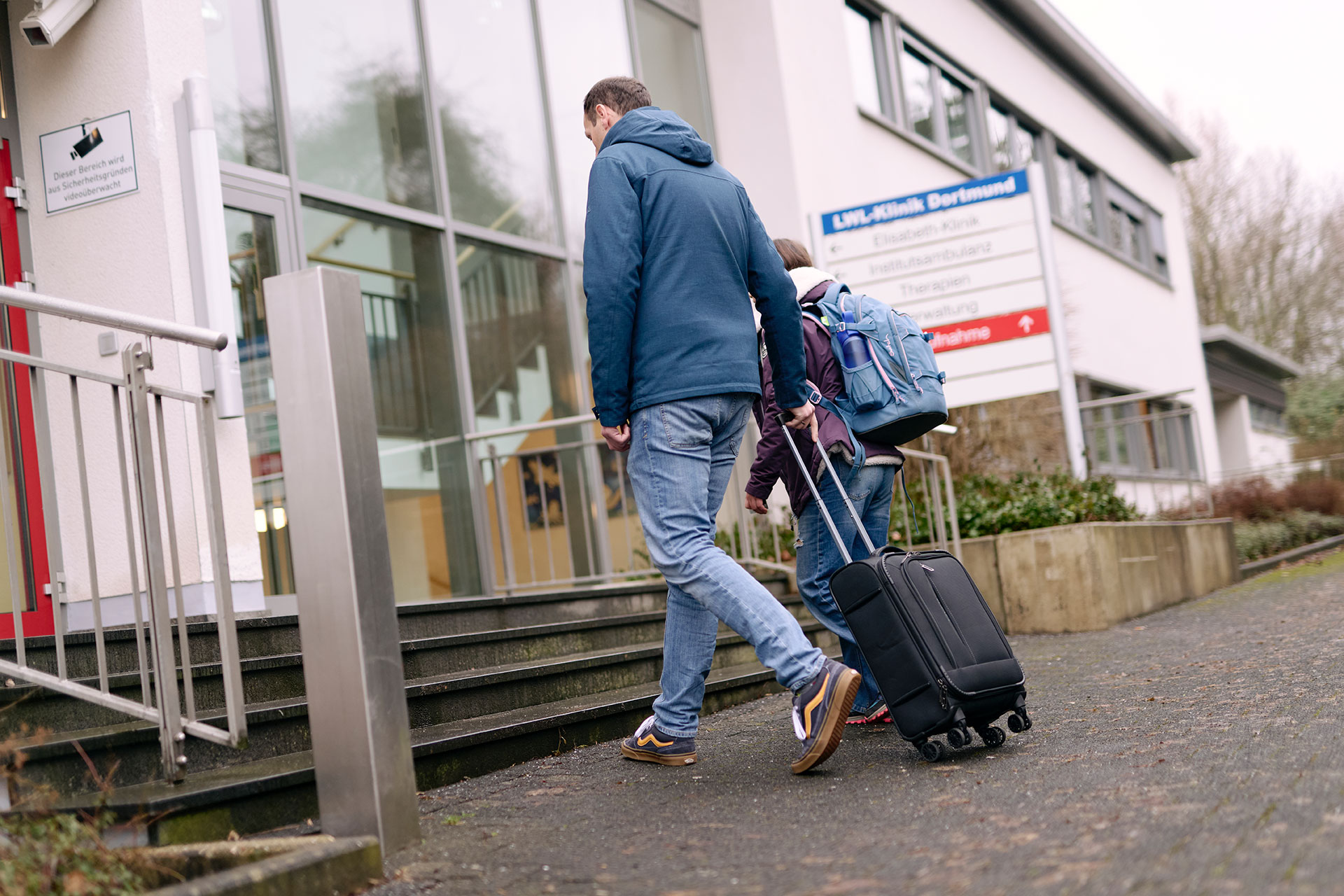 Zwei Personen gehen in die Klinik.