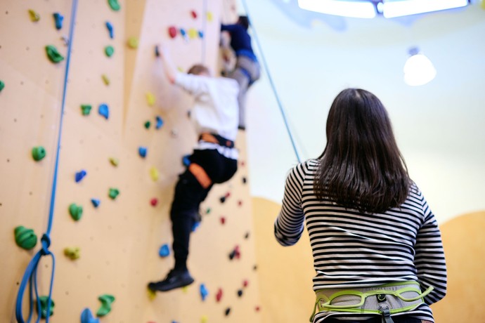 Ein Kind klettert an einer Kletterwand.