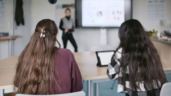 Schülerinnen sitzen in einem Klassenzimmer und arbeiten. Schülerinnen sitzen in einem Klassenzimmer und arbeiten.