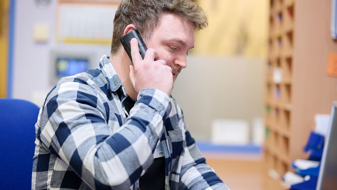 Das Bild zeigt eine Person, die telefoniert.